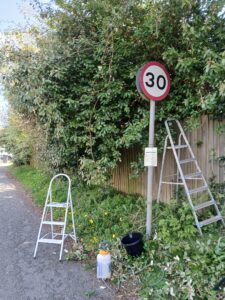 Clean road sign with ladders and cleaning equipment